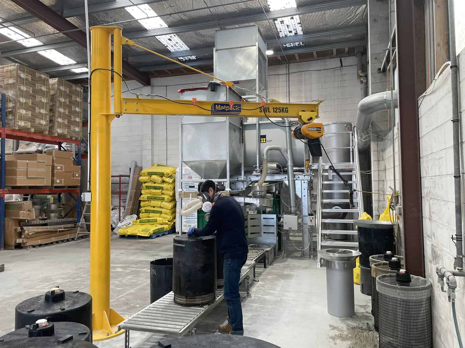 Operator working at the Stormwater360 cartridge loading station with filtration cartridges on the conveyor
