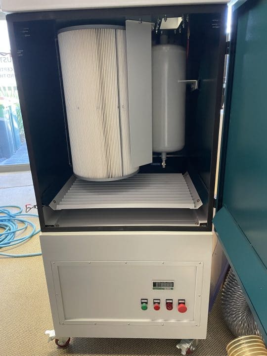Welding fume collector with cabinet door open, showing the pleated filter cartridge installed inside